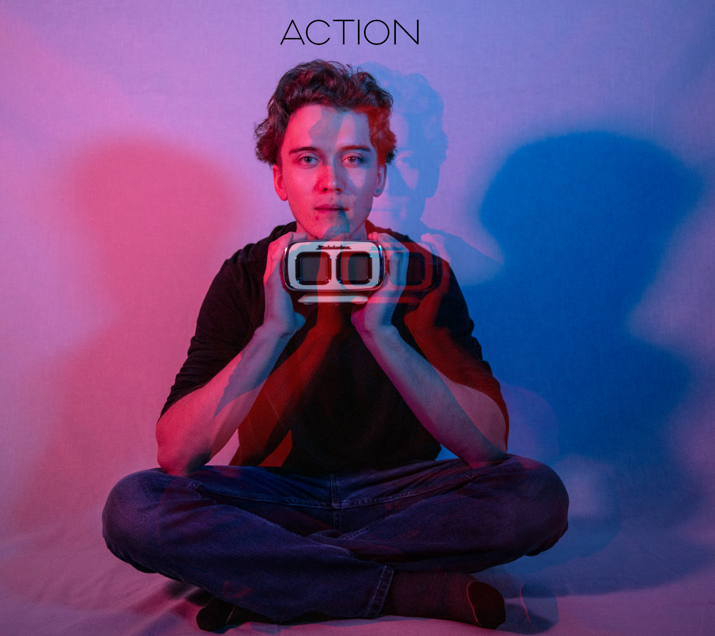 An album cover photo that Jailyn took. The name of the album action is at the top and the main photo is a white man with short blonde hair and blue eyes. He is sitting criss-cross in front of a white background and holding a clock in his hands.